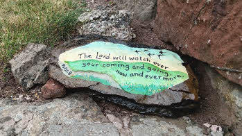 A painted stone with the text The Lord will watch over your company and going, now and evermore. Psalms 121:7-8