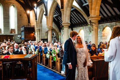 A wedding couple, their guests and the rector, viewed from the west end of Holy Trinity Church, Leaton