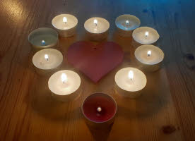 An heart-shaped arrangement of lit tealights